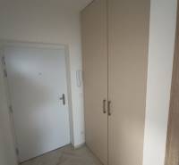 Eingangsflur mit weißen Türen und einem großen Schrank in einer 2-Zimmer-Wohnung.