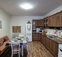 Küche in einem Einfamilienhaus mit Holzschränken und einem Boden in Holzoptik.