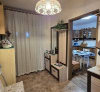 Eingangsbereich in einem Einfamilienhaus mit Garderobe, Spiegel und Zugang zur Küche mit Esstisch.