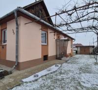 Ein Einfamilienhaus in der Neuen Straße in Veľké Ozorovce mit einem Rohrpavillon und einem verschneiten Garten.