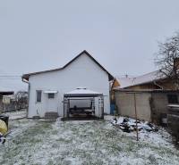 Ein verschneiter Hof mit einem Unterstand hinter einem Einfamilienhaus in der Straße Nová, Veľké Ozorovce.