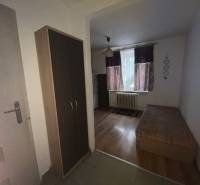 In der Einzimmerwohnung sieht man einen Boden mit Holzdekor, ein Bett und einen Schrank.