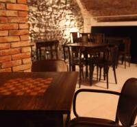 Rustikale Gastrobereiche mit Steinwänden und einem Boden in Holzoptik.