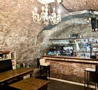 Antiker Stil in Gastroräumen mit einer Backsteinbar und Büchern unter dem Kronleuchter.