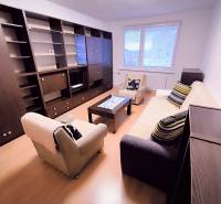 Wohnzimmer in einer 2-Zimmer-Wohnung mit Sofa, Sesseln und Möbelwand.