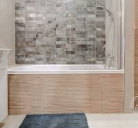 Badezimmer in einer 2-Zimmer-Wohnung mit Badewanne, Waschbecken und Toilette, gefliest.