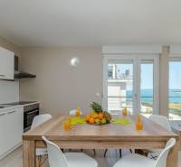 Ferienwohnung mit Meerblick, Esstisch und Küchenzeile.