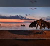 Das Foto zeigt einen Strandabend mit Palmen und einer Auszeichnung der Immobilienagentur Reality BICIAŇ.