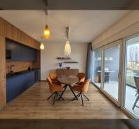 Essbereich mit Holzboden und großen Fenstern in einer Ferienwohnung.