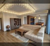 Wohnzimmer in einer Ferienwohnung mit Holzboden, Sofa und Hängelampen.