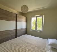 Schlafzimmer in einem Einfamilienhaus mit französischem Fenster und großem Kleiderschrank.