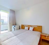 Schlafzimmer in einer 3-Zimmer-Wohnung mit Bett und Blick durch die Balkontür.