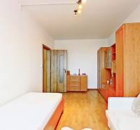 Ein Zimmer in einer 3-Zimmer-Wohnung mit einem Boden in Holzoptik und einfacher Einrichtung.