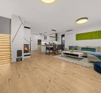 Wohnzimmer einer 4-Zimmer-Wohnung mit Holzboden, Kamin und modernem Treppenhaus.
