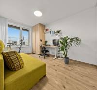 Arbeitszimmer in einer Vierzimmerwohnung mit dekorativem Boden, gelbem Sofa und großem Fenster.