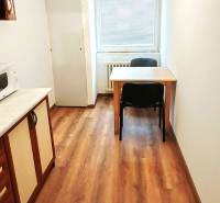 Küche in einer 3-Zimmer-Wohnung mit Holzboden und einem Tisch für zwei Personen.