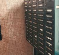 Briefkästen im Flur einer 3-Zimmer-Wohnung, Wand mit Ziegelverkleidung, Böden mit Steindekor.