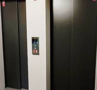 Zwei Aufzüge mit Metalltüren und einem Bedienfeld dazwischen.