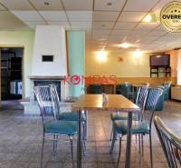 Gewerbeflächen mit stilvollen Stühlen, Tisch und Kamin, geeignet für Veranstaltungen.