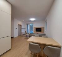 Wohnzimmer in einer 2-Zimmer-Wohnung mit Holzboden und offener Küche.