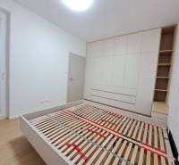Schlafzimmer mit Holzboden, Einbauschrank und Bett in einer 2-Zimmer-Wohnung.