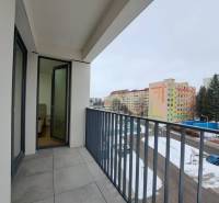 Balkon einer 2-Zimmer-Wohnung in Poprad mit Blick auf eine verschneite städtische Gasse.