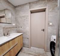 Badezimmer mit Waschbecken und Boden in Holzoptik in einer 2-Zimmer-Wohnung.