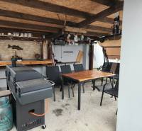 Überdachte Sitzecke in einem Einfamilienhaus in Tornyosnémeti mit Grill und Tisch.