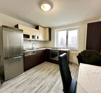 Küche in einer 2-Zimmer-Wohnung mit Holzboden und einem Tisch mit Stühlen.