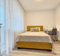 Schlafzimmer in einer Einzimmerwohnung mit Bett, Schreibtisch und Holzboden.