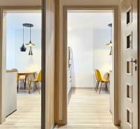 Ein helles Esszimmer mit einem Küchentisch und gelben Stühlen in einer Einzimmerwohnung.