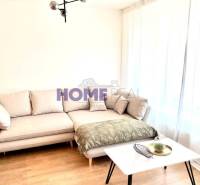 Wohnzimmer in einer 3-Zimmer-Wohnung mit Sofa, Tisch und Holzboden.