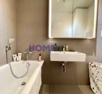 Badezimmer mit Badewanne und Spiegel in einer 3-Zimmer-Wohnung.