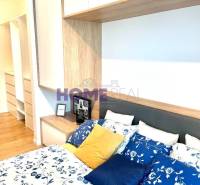 Schlafzimmer in einer 3-Zimmer-Wohnung mit Bett, bunten Kissen und Stauraum.