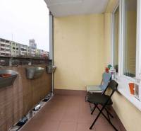 Balkon einer 2-Zimmer-Wohnung in der Jégeho 8 in Bratislava-Ružinov mit Blumenkästen und Stühlen.