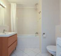 Badezimmer mit Badewanne, Waschbecken, Schrank, Toilette und Waschmaschine in einer 2-Zimmer-Wohnung.