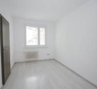 Ein Zimmer mit Fenster, Heizkörper und Boden in Holzoptik in einer 3-Zimmer-Wohnung.
