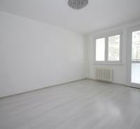 Ein Zimmer in einer 3-Zimmer-Wohnung mit Holzboden und großen Fenstern.