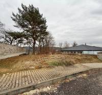 Baugrundstück in Groß-Bytča in der Stadt Bytča mit Gehweg und Bäumen.