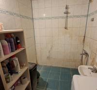 Gemütliches Badezimmer mit Waschmaschine, weißen Fliesen und Regalen, ideal für eine 3-Zimmer-Wohnung.