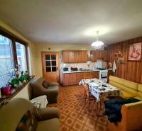 Küche in einem Einfamilienhaus mit Holzdekor, Sitzgarnitur und Esstisch.