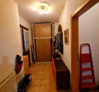 Flur in einem Einfamilienhaus mit Fliesen, Schuhschrank, Garderobe und Schrank.