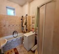 Badezimmer mit Badewanne, Dusche und Waschmaschine in einem Einfamilienhaus.