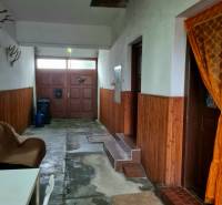 Innenraum eines Einfamilienhauses mit Eingangstür, Stuhl und Wanddekorationen.