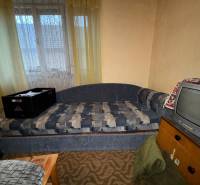 Ein Sofa und ein Fernseher im Wohnzimmer eines Einfamilienhauses mit Vintage-Innendekoration.