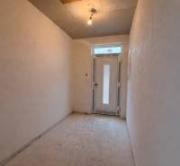 Ein Flur in einem Einfamilienhaus mit einfacher Beleuchtung und Kunststofftüren.