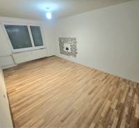 Wohnzimmer mit Holzboden und Fenster in einer 3-Zimmer-Wohnung.