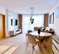 Wohnzimmer in einer 3-Zimmer-Wohnung mit hellen Möbeln und einem Boden in Holzoptik.