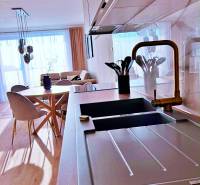 Küche in einer 3-Zimmer-Wohnung mit hellem Boden in Holzoptik und stilvollem Sitzbereich.