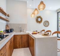 Innenraum der Villa mit Küchenzeile, Holzschränken und dekorativen Spiegeln.